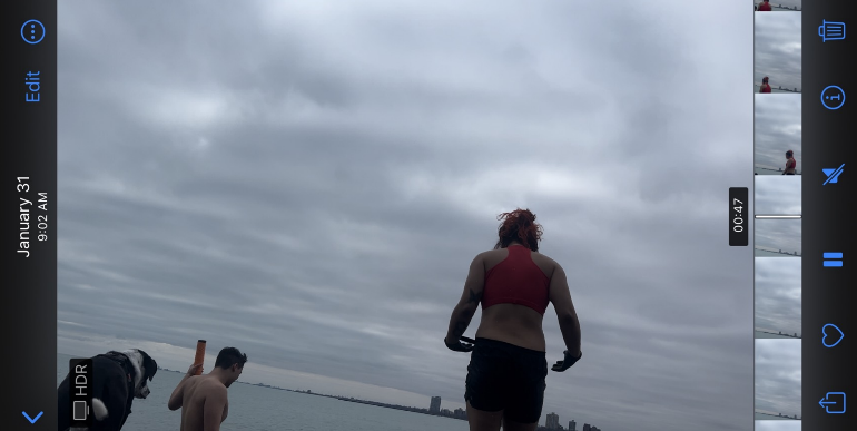 picture of Vera from behind, red swim top black shorts. Martin and his dog Koji on the left. Everyone looking down at the lake. Sky is overcast and cloudy.